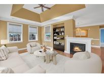 Comfortable living room with a cozy fireplace, built-in shelves, plush seating, and plenty of natural light from large windows at 10421 Rosegate Ct # 303, Raleigh, NC 27617