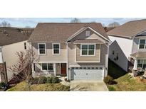 Charming two-story home featuring neutral siding, an attached two-car garage, and a cozy front porch at 1055 Kerr St, Burlington, NC 27215