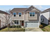 Charming two-story home featuring a front porch, attached garage, and neutral-toned siding at 1055 Kerr St, Burlington, NC 27215