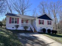 Charming one-story home featuring a quaint front porch and driveway at 1104 Thelonious Dr, Raleigh, NC 27610