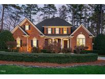 Charming brick home with manicured landscaping, lush green lawn, and inviting curb appeal at 112 Trellingwood Dr, Morrisville, NC 27560