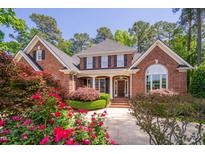 Charming two-story brick home featuring a manicured lawn and beautiful landscaping at 112 Trellingwood Dr, Morrisville, NC 27560