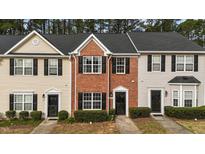 Charming townhomes featuring varied facades, dark shutters, and manicured landscaping at 116 Anterbury Dr, Apex, NC 27502