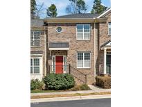 Charming brick townhome with a bright red door and manicured landscaping at 138 Tressel Way, Durham, NC 27707