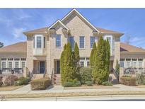 Charming townhome exterior featuring brick facade, bay windows, and well-maintained landscaping at 203 Valleyshire Rd, Durham, NC 27707