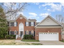 Charming two-story brick home with an attached two-car garage and landscaped yard at 205 Quarryrock Rd, Holly Springs, NC 27540