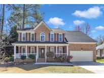 Charming brick two-story home featuring a welcoming front porch and attached two-car garage at 207 Lewey Brook Dr, Cary, NC 27519