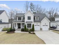 Beautiful two story home with white siding, stone accents, and a well-manicured front yard at 2073 Amalfi Pl, Apex, NC 27502