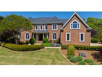Stately brick home with lush landscaping, trimmed hedges and manicured lawn at 212 Whirlaway Ln, Chapel Hill, NC 27516