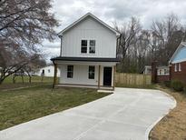 Charming two-story home with a modern design and a concrete driveway at 213 Johnston St, Bunn, NC 27508