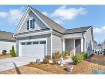Charming single-story home featuring a two-car garage, gray siding, and manicured landscaping at 244 Mahogany Run, Raleigh, NC 27610