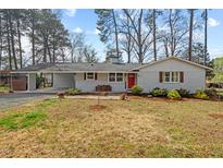 Charming single-story home featuring a light gray painted brick exterior and a welcoming red front door at 2611 Newport Dr, Durham, NC 27705