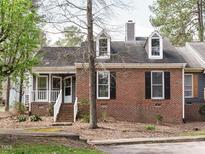 Charming brick home with a well-manicured lawn, dormer windows, and inviting front porch at 27 Kings Mount Ct, Durham, NC 27713