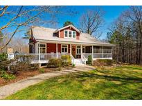 Charming red home with a metal roof, inviting front porch, and well-maintained landscaping at 3227 Morrow Farm Ln, Chapel Hill, NC 27516