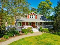 Charming red two-story home with a welcoming front porch and beautifully landscaped front yard at 3227 Morrow Farm Ln, Chapel Hill, NC 27516