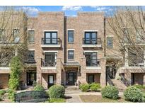 Charming brick townhome featuring multiple stories, private balconies, and inviting landscaping at 500 John Haywood Way # 103, Raleigh, NC 27604