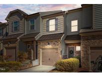 Charming townhome with stone accents, attached garage, and professionally landscaped yard at 517 Aronia Dr, Hillsborough, NC 27278