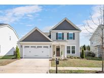 Charming two-story home featuring a two-car garage, neutral siding, and a welcoming front door at 724 Summer Music Ln, Raleigh, NC 27603