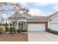 Charming townhome featuring a two-car garage, brick accents, and a well-manicured front yard at 734 Hornchurch Loop, Cary, NC 27519