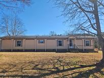 Single-story home with tan siding, neutral trim, and front porch at 8025 Hebron Church Rd, Garner, NC 27529