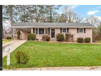 Charming single-story home with brick facade, manicured lawn, mature landscaping, and a welcoming front entrance at 902 Long Ave, Garner, NC 27529