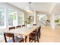 Bright dining room with large windows, wood table, modern light fixture, and light wood floors at 912 Cheviot Ave, Durham, NC 27707