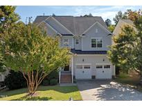 Beautiful two-story home with a well-manicured lawn and a two-car garage and lovely trees at 957 Vandalia Dr, Cary, NC 27519