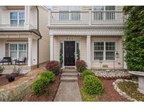 Charming home featuring a black front door, elegant columns, and beautiful landscaping at 992 Ambergate, Apex, NC 27502