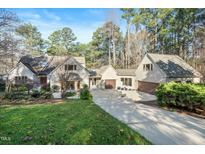 Charming home featuring mature trees, attached garages and lush, landscaped front yard at 12117 Cliffside Cir, Raleigh, NC 27614