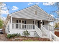 Charming home featuring gray siding, black shutters, a welcoming porch, and well-maintained landscaping at 1304 Drew St, Durham, NC 27701