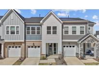 Beautiful townhome featuring a two-car garage, manicured lawn, and modern architectural details at 175 Norwell Ln, Pittsboro, NC 27312