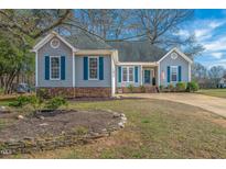 Charming home with gray siding, blue shutters, brick accents, and well-maintained front yard at 201 Somerset Farm Dr, Holly Springs, NC 27540