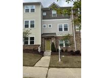 Inviting townhome featuring a mix of brick and siding, with a neatly landscaped front yard and a bright, welcoming entrance at 219 Adobe Pl, Cary, NC 27519