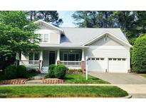 Charming two-story home boasts a welcoming front porch, attached two-car garage and beautifully landscaped yard at 2429 Falls River Ave, Raleigh, NC 27614