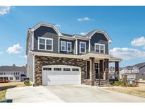 Charming two-story home featuring stone accents, a covered porch and a pristine white garage door at 251 North Crest Dr, Chapel Hill, NC 27517