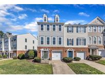 Charming brick townhomes with well-manicured lawns under a bright blue partially cloudy sky at 301 Coral Creek Ln, Morrisville, NC 27560
