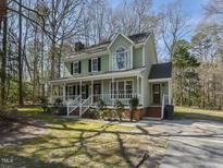 Charming two-story home boasts a welcoming porch and beautiful green lawn and mature landscaping at 3313 Ventura Cir, Wake Forest, NC 27587