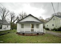 Charming white bungalow with a cozy front porch and a well-maintained lawn at 423 E Rockspring St, Henderson, NC 27536