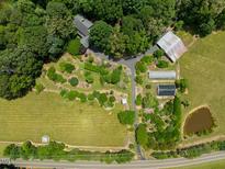 Estate aerial view featuring house, lush landscaping, pond, barns, and open fields at 4811 New Sharon Church Rd, Hillsborough, NC 27278