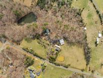 Expansive aerial view of the property featuring a pond and various outbuildings at 4811 New Sharon Church Road, Hillsborough, NC 27278