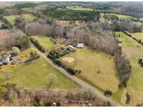 Expansive aerial view of a beautiful lot with mature trees, open pasture and a home at 4811 New Sharon Church Rd, Hillsborough, NC 27278