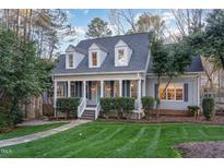 Charming home featuring a landscaped front yard and a welcoming covered front porch with classic architectural details at 5000 Celbridge Pl, Raleigh, NC 27613