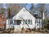 Charming single-Gathering home with a white exterior, black shutters, brick foundation, and well-manicured front yard at 517 E Club Blvd, Durham, NC 27704