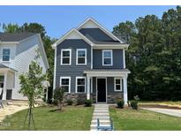 Beautiful two-story home featuring gray siding, a stone base, and a neatly manicured lawn at 5640 Cayden Cove Dr, Wendell, NC 27591