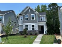 Charming two-story home with stone accents and well-maintained landscaping and covered front entryway at 5648 Cayden Cove Dr, Wendell, NC 27591