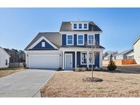 Charming two-story home with blue siding, white trim, and an attached two-car garage at 65 Hickory Run Ln, Franklinton, NC 27525