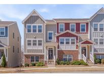 Charming townhome with a red brick and neutral-colored exterior and neatly maintained front yard at 829 Winter Meadow Dr, Wake Forest, NC 27587