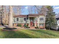 Charming split-level home with a red front door, green siding, and brick accents at 918 Templeridge Rd, Wake Forest, NC 27587