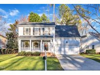Charming two-story home with a covered front porch, attached garage, and manicured lawn on a sunny day at 9240 Shallcross Way, Raleigh, NC 27617