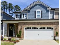 Charming two-story home featuring a brick facade, two-car garage, and well-maintained landscaping at 938 Haybeck Ln, Apex, NC 27523